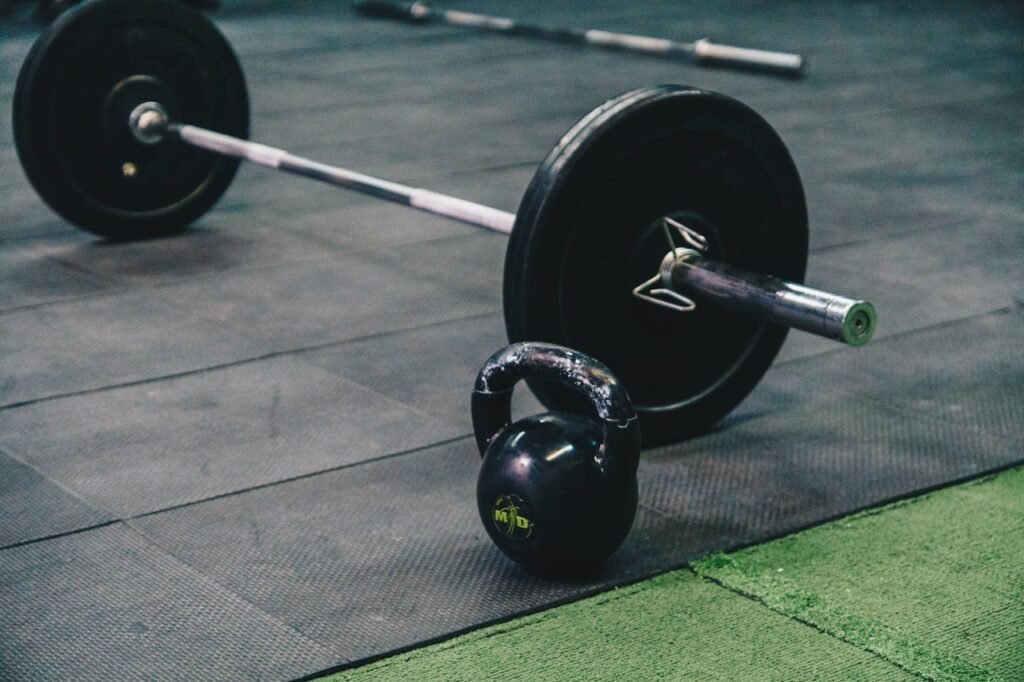 Barbell and kettlebell on a gym floor, ideal for resistance training