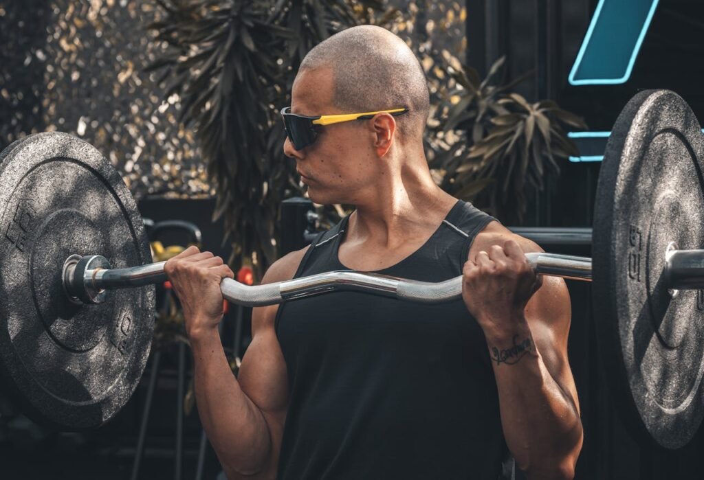 Man performing a barbell bicep curl, focusing on building arm strength