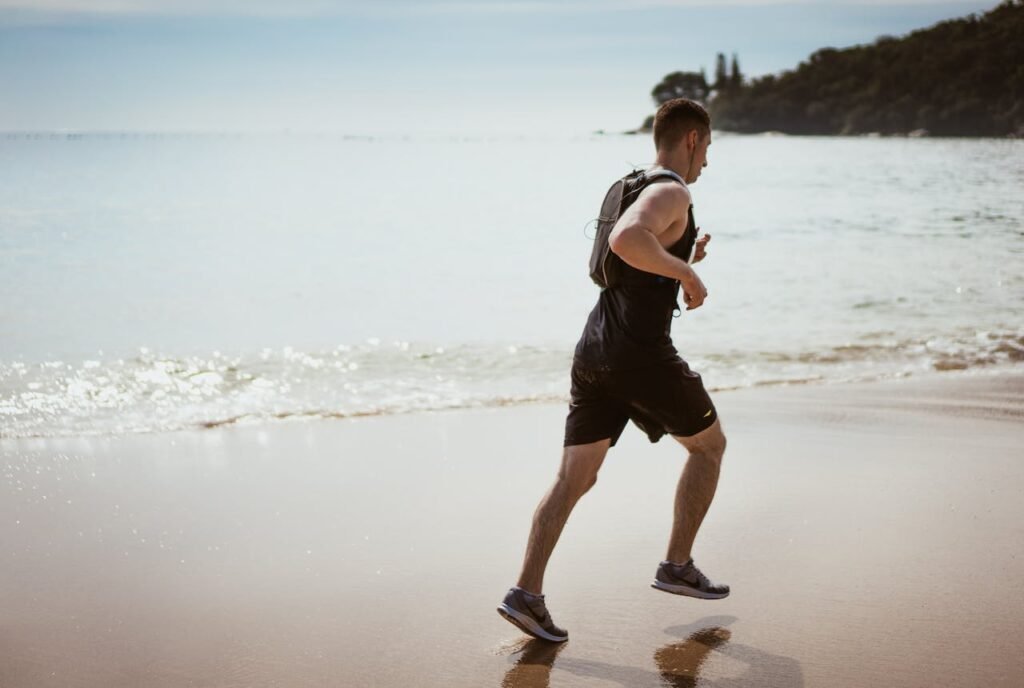 Person running on a sandy beach by the ocean