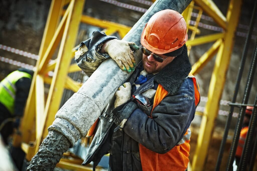 Construction worker pouring concrete, demonstrating hard physical labor