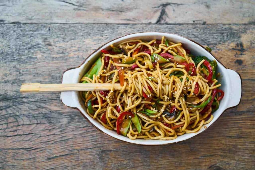 A big serving of stir fry with noodles and lots of vegetables shows a good hot lunch option.