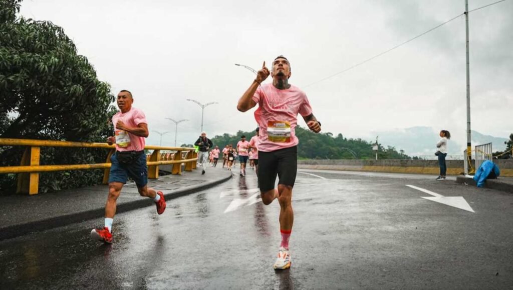 Two men are running a marathon, one pointing up to the sky as they achieve their ultimate goal.