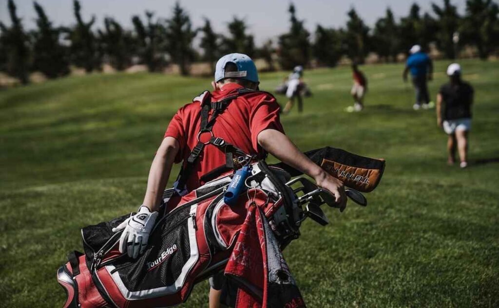 A Golfer walking the green carrying golf bag, the everyday type of real fitness.