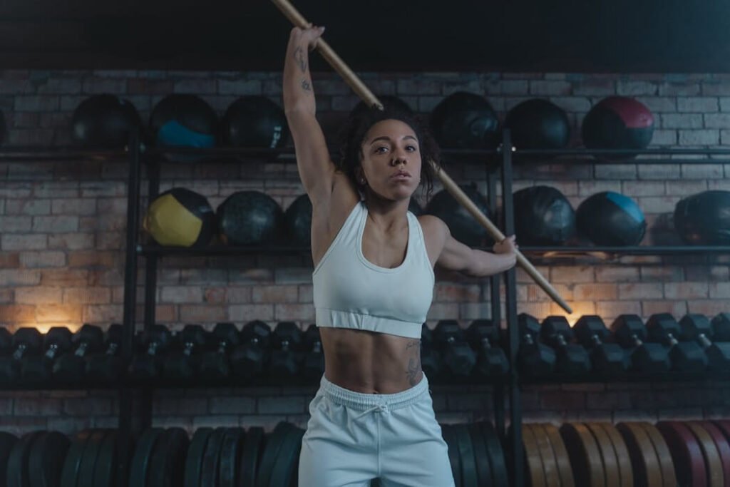 woman stretching in gym, doing dynamic moment for recovery.