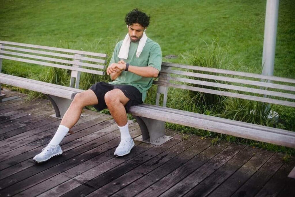 Guy sitting on a park bench, resting from his run.