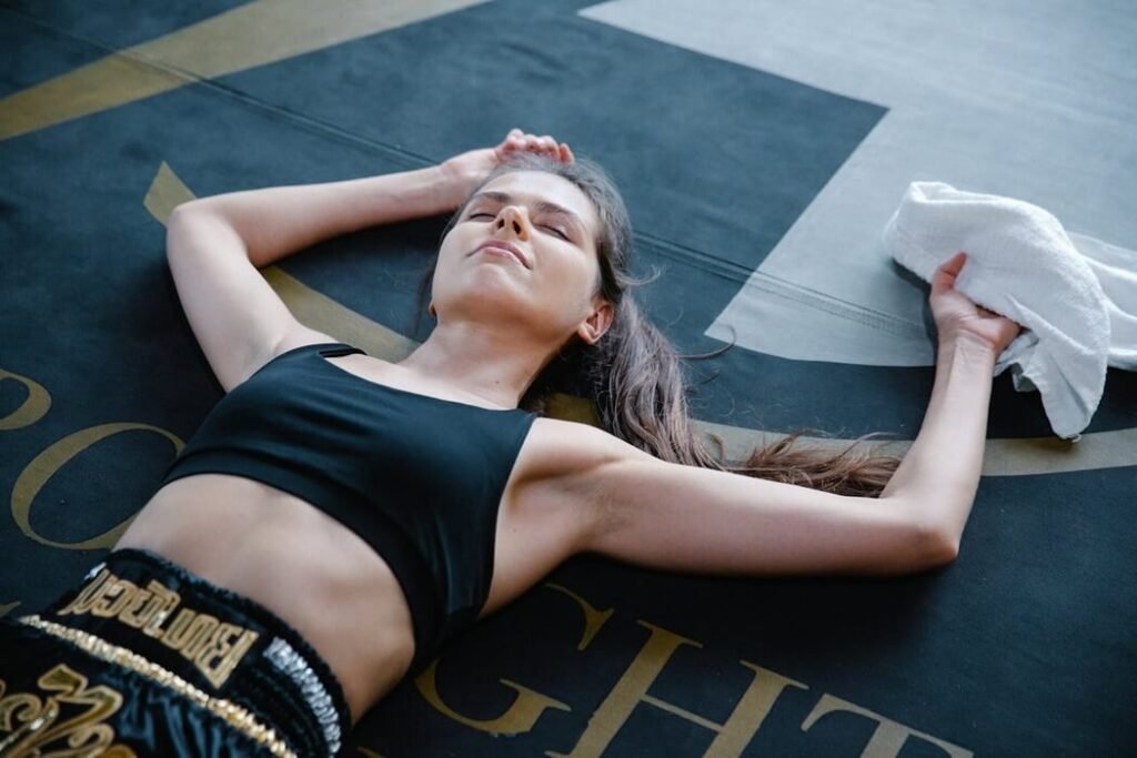 Woman lying on the gym floor resting and recovering from a work out.