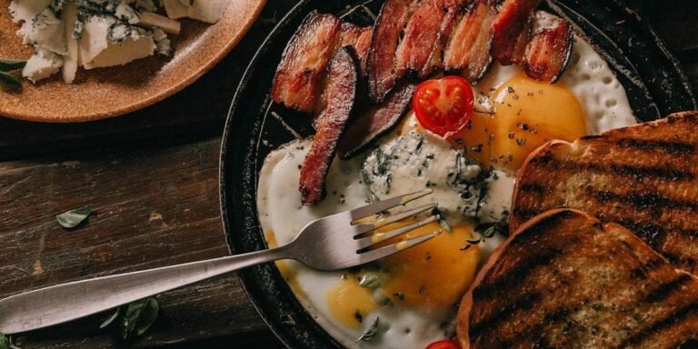 Full plate of breakfast with eggs, bacon, cheese, and toast representing protein essentials for a balanced diet.