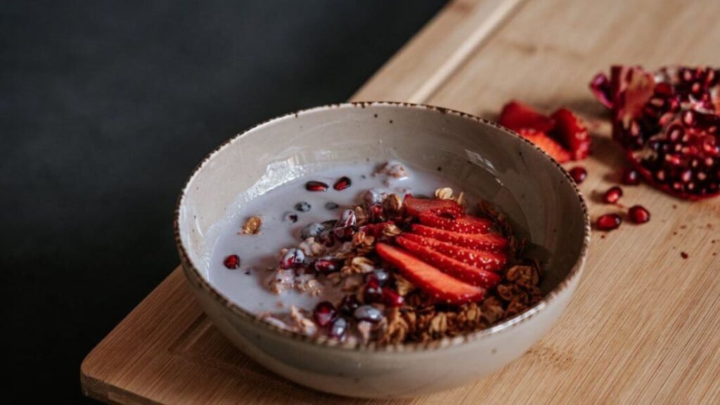 High-protein breakfast meal prep for tradies, a bowl with granola, milk, and strawberries