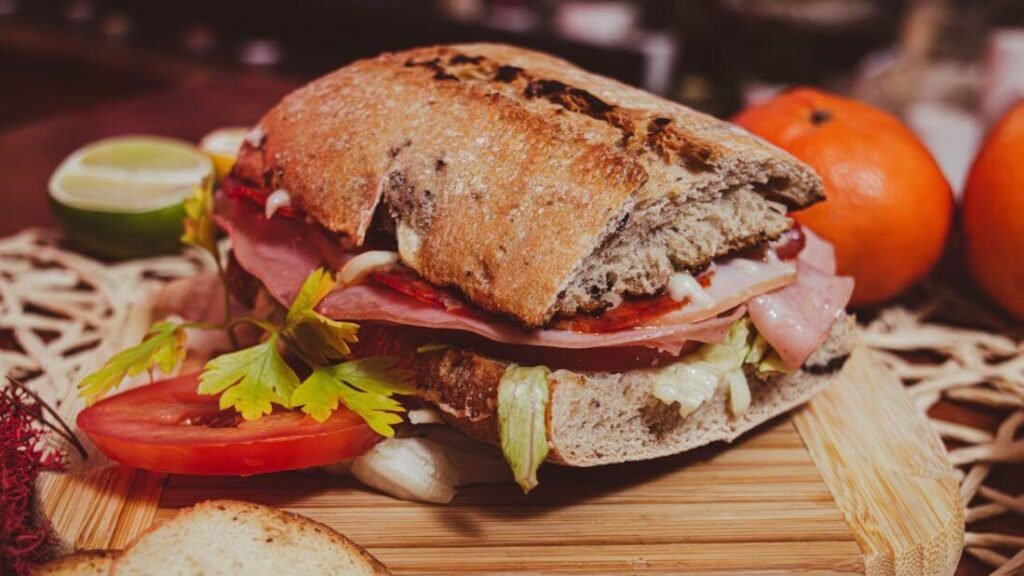 Ham and vegetable sandwich on a cutting board, prepared as a work lunch meal prep