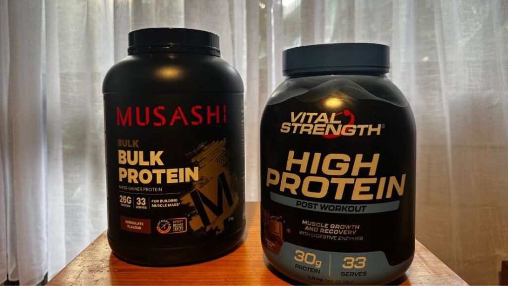 Two different protein powder options in Australia: Vital Strength High Protein Concentrate and Musashi Bulk Protein, shown side by side.