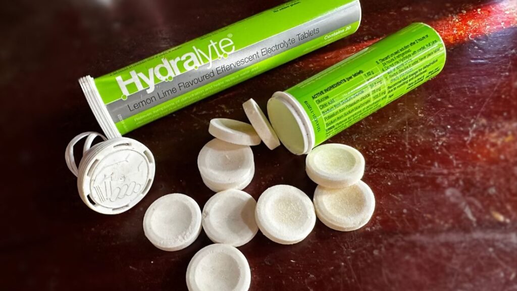 Two containers of Hydralyte electrolyte tablets in lemon lime flavour on a bench, used for hydration support during training and recovery.
