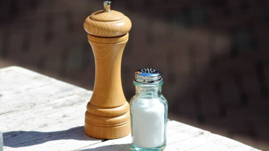 Salt and pepper shakers on a bench symbolising sodium and chloride as key components of table salt.