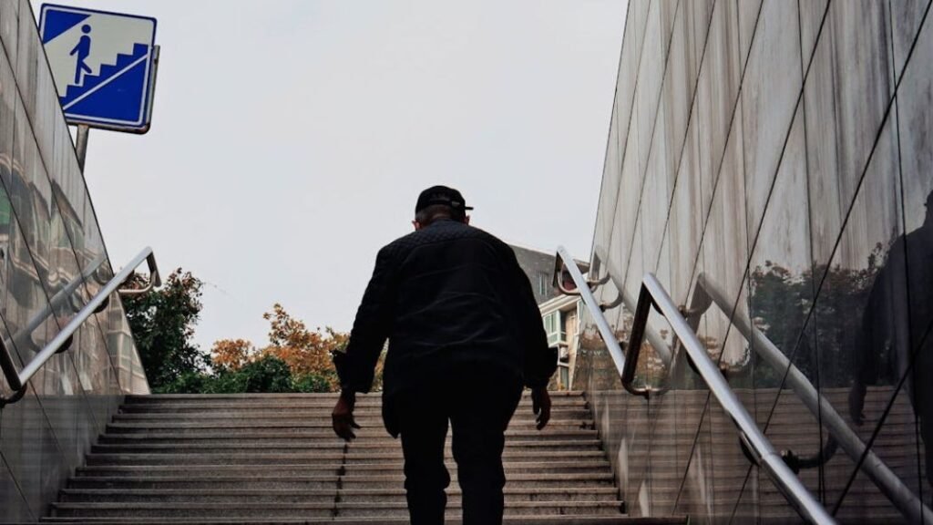 Older man walking up stairs to increase walking intensity