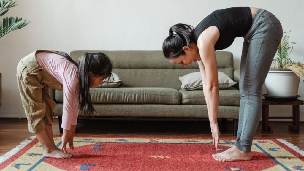 Adult and child stretching together on their living room floor.