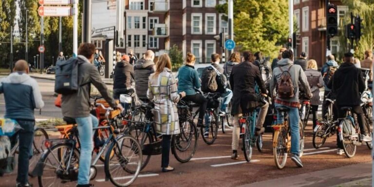 Busy city street with people walking and cycling, representing how to stay fit when busy.