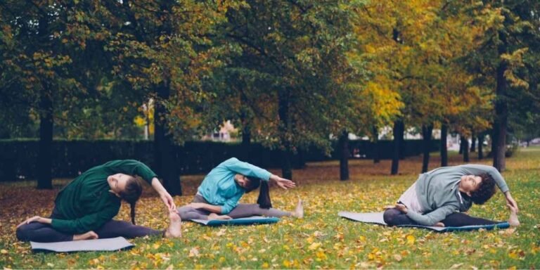 three people in a park stretching