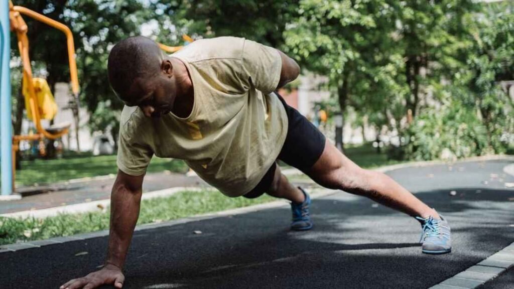 Man performing a one-arm push-up at an outdoor calisthenics park